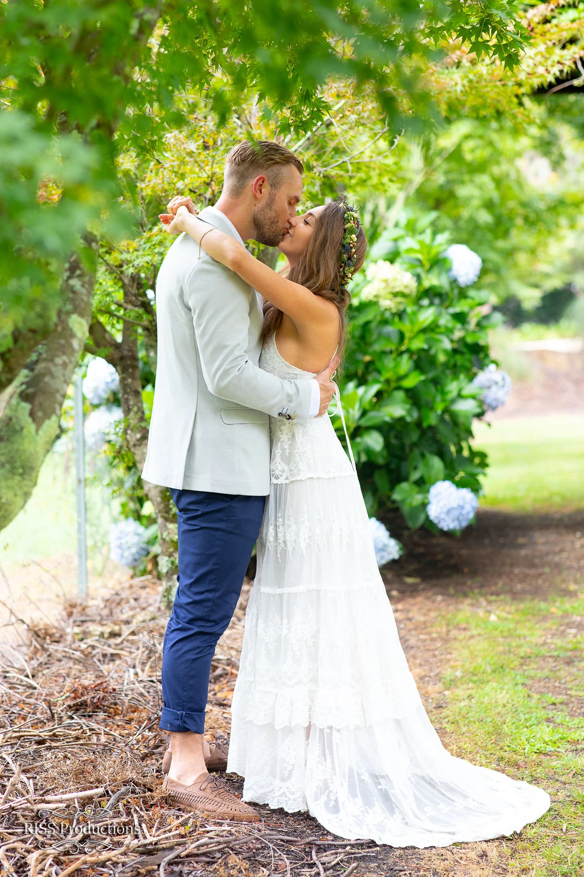 Brooke and Ben embracing beneath a tree in a Blue Mountains garden