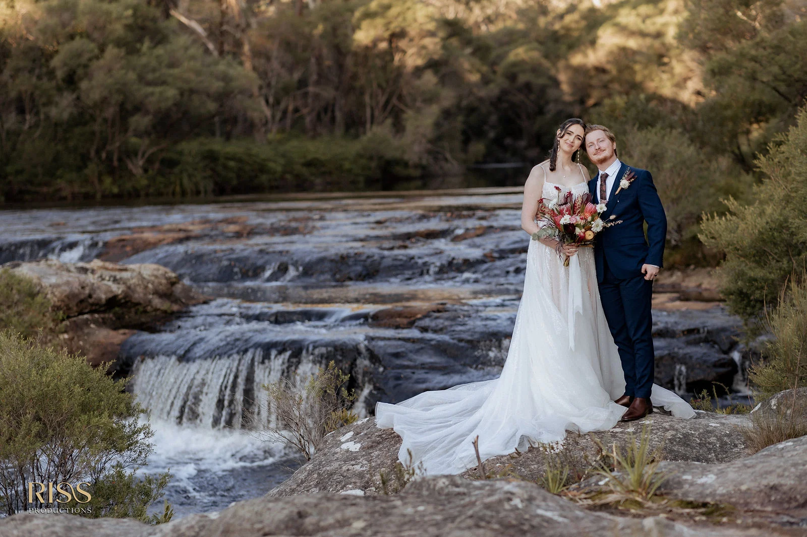 Caitlin and Jakub standing beside a waterfall in the Southern Highlands