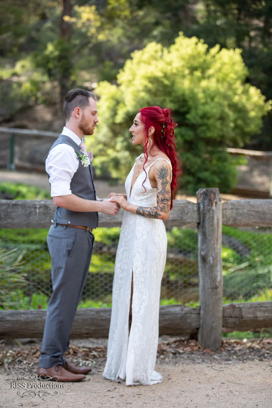 Giacinta and Brandon holding hands by a rustic fence near Lithgow