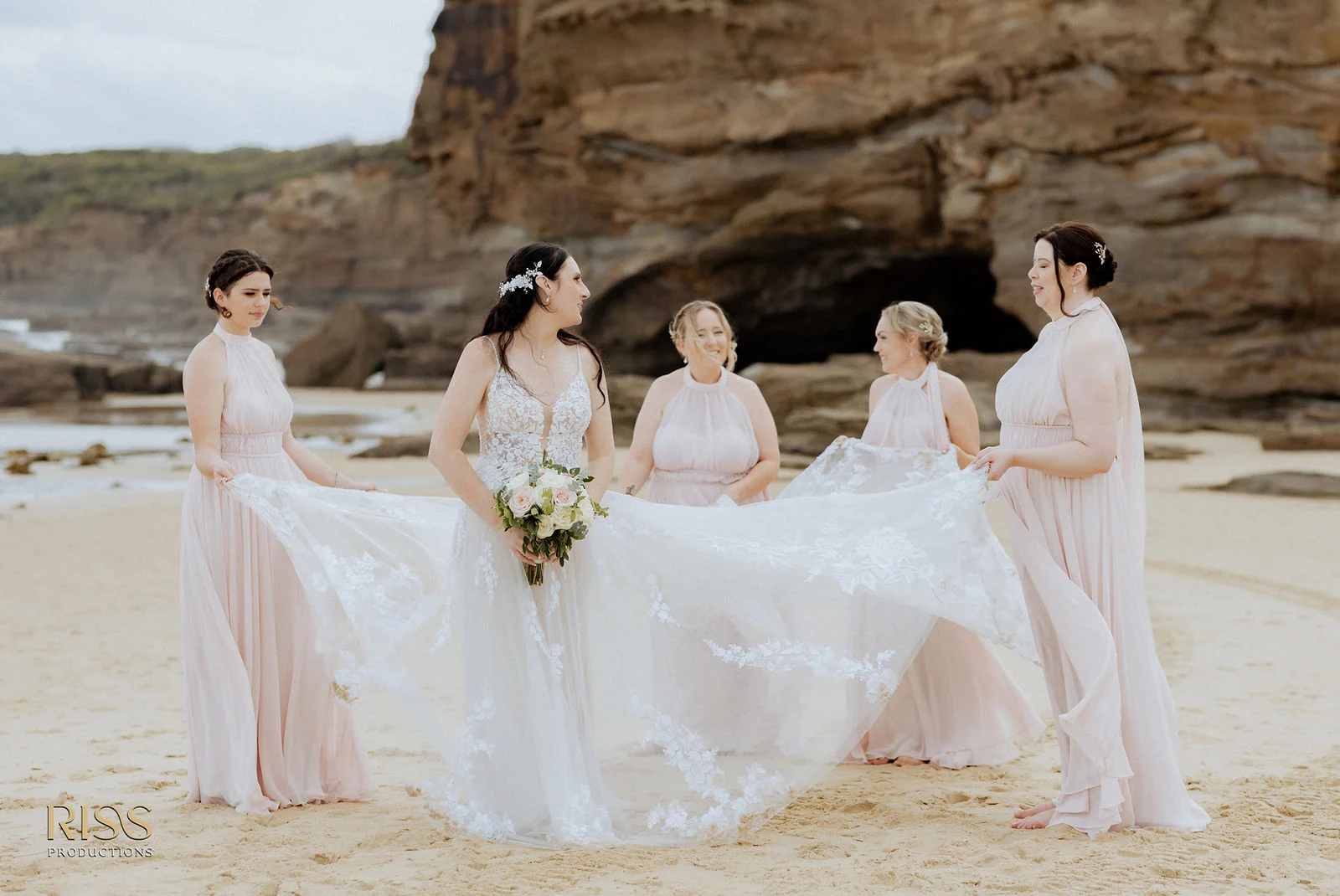 Bride with her bridesmaids on the sand at Caves Beach