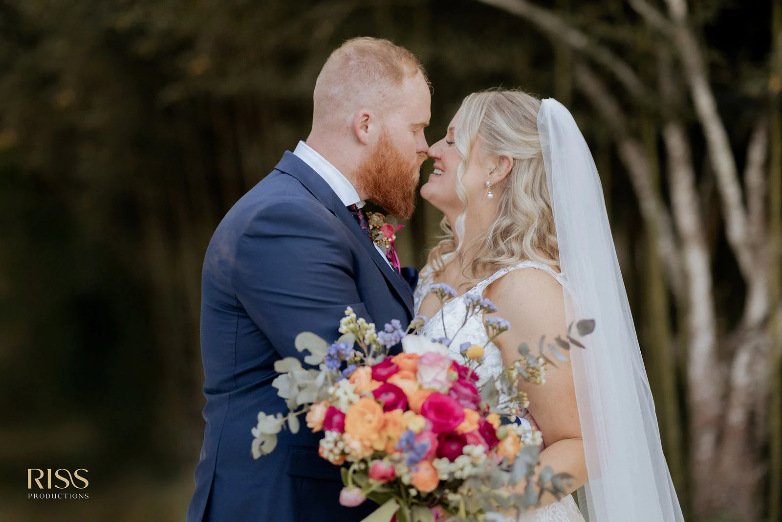 Tamara and Callan sharing a kiss with her bouquet, Central Coast wedding